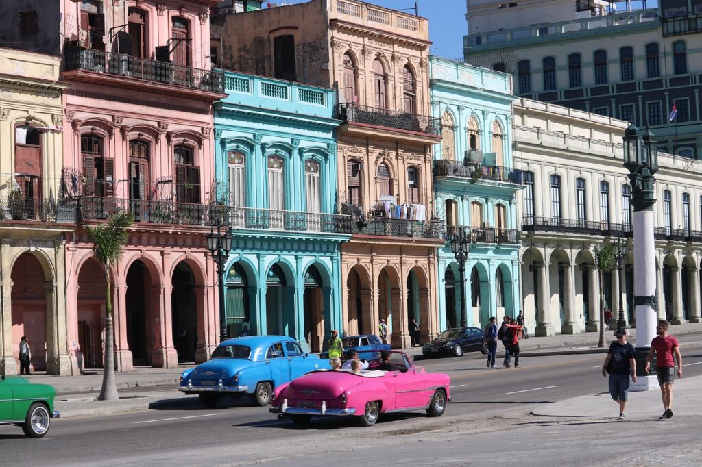 a group of cars on a street with buildings in the background