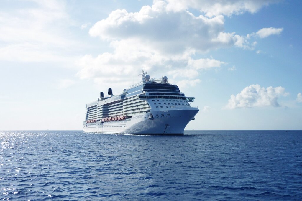 large cruise ship sailing on the calm Mediterranean sea against a clear blue sky.